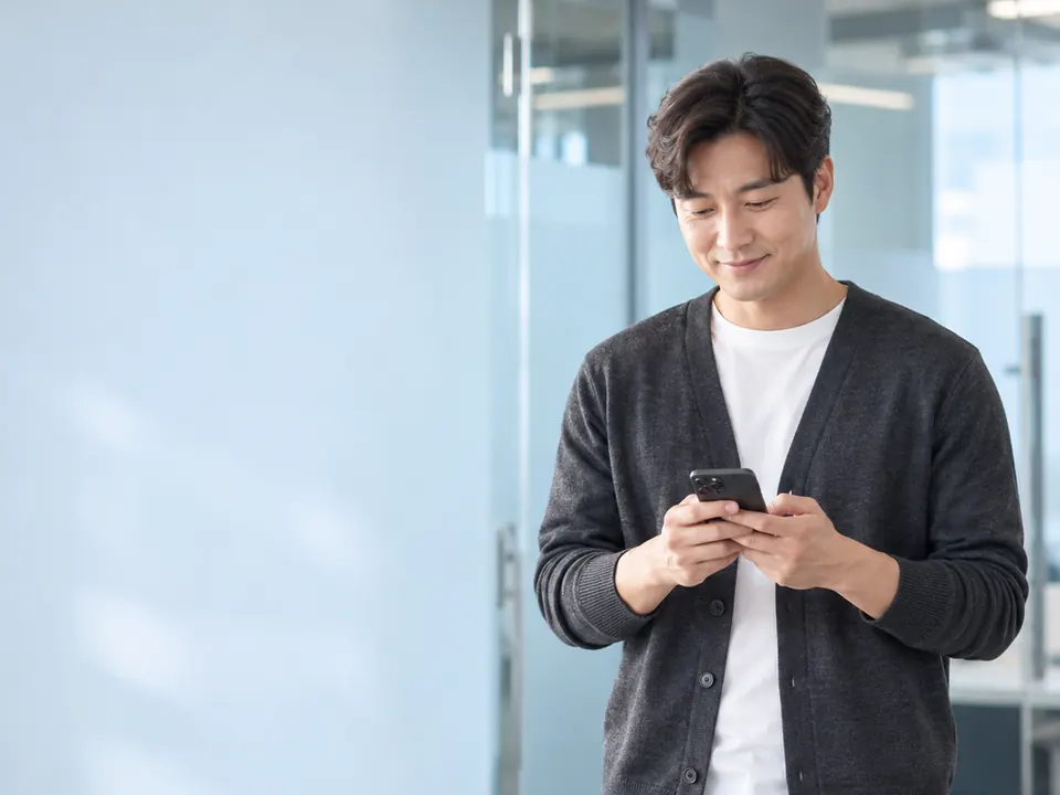 사무실 복도에서 휴대전화를 보는 직장인