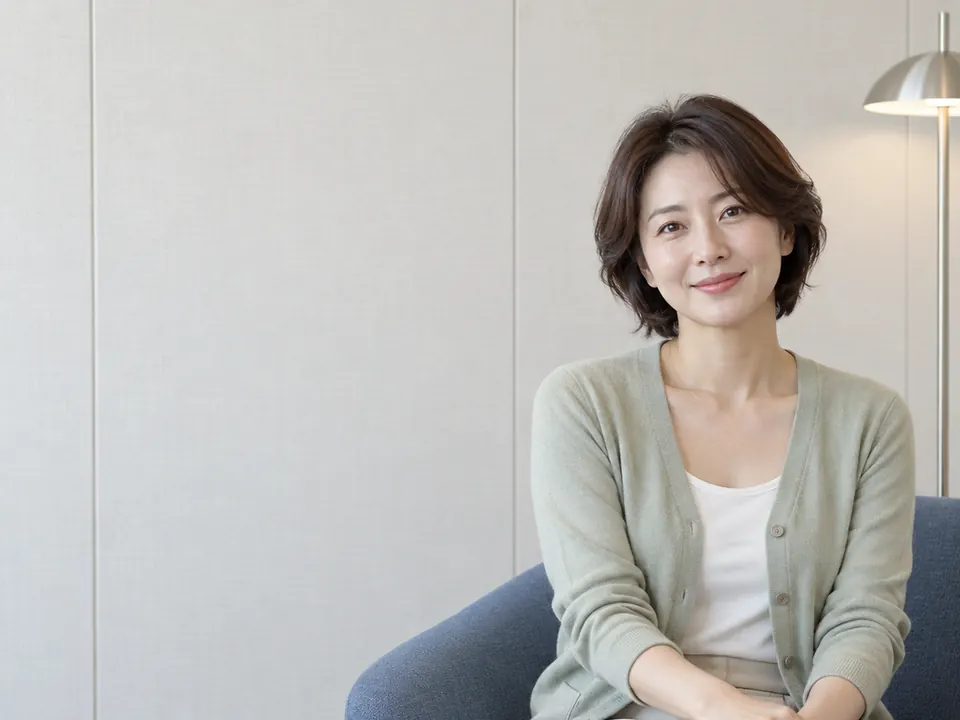 소파에 앉아 차분히 미소 짓는 여성