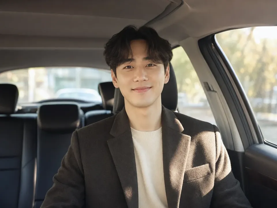 차 안에서 웃으며 이야기하는 남성
